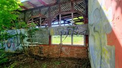 Blick hinter einen Bauzaun, Überreste einer alten Scheune