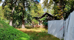 Hinter Bäumen versteckte alte Scheune